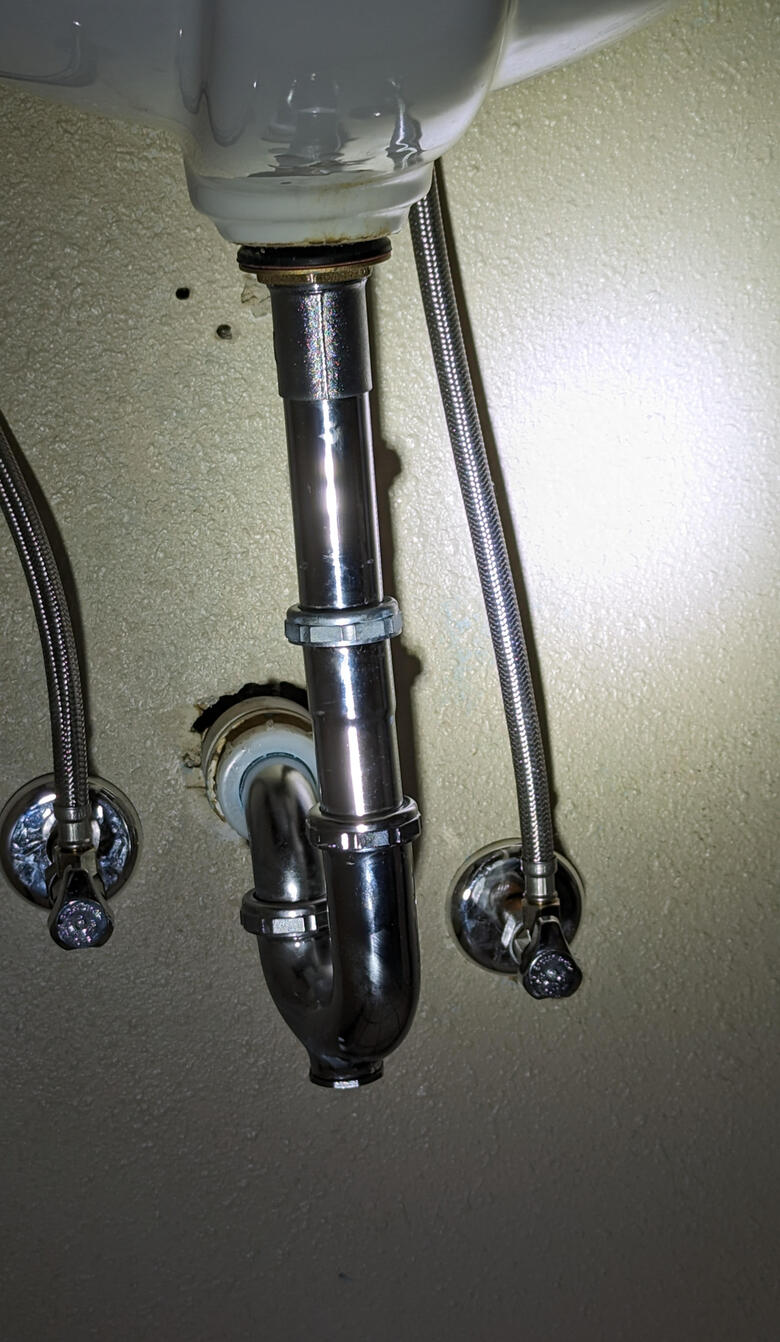 Under-sink plumbing - Third Day - Des Moines - Iowa Under-sink plumbing with metal P-trap, drain pipe, and two flexible water supply lines connected to shut-off valves installed by Third Day Plumbing - Des Moines Iowa.